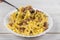 Spirals pasta Bolognese. Tagliatelle with minced meat on a white plate on a wooden background