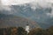 Spire of the church in the village of PraÅ¾mo in the heart of the Beskydy mountains, with the morning mist and the surrounding