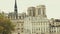 Spire of the famous Notre-Dame Cathedral and old residential houses in Paris, France