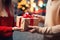 In the spirit of the holiday, a couple\\\'s hands hold a festive gift box