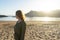 Spiritual adolescent in green dress admire the sunset and the sea town on a hill in Tenerife. Blonde romantic woman look the