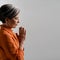 Spiritual Caucasian woman prays with her hands clasped. Side view of meditating mature woman with closed eyes. Square