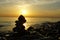 Spiritual and meditative summer background with stacking stones at golden hour during sea sunset