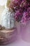 Spiritual zen meditation face of Buddha with beautiful violet branch lilac flowers. Home decor, still life concept