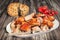 Spit Roasted Pork Shoulder Slices Served With Torn Pitta Flatbread And Bunch Of Cherry Tomatoes On Old Weathered Garden Table