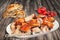 Spit Roasted Pork Shoulder Slices Served With Torn Pitta Flatbread And Bunch Of Cherry Tomatoes On Old Weathered Garden Table