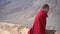 Spiti, Himachal Pradesh - 2 July 2022 - A tibetian monk walking wearing a red cloth in spiti valley