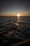 Splash from rowing wooden oar on boat on a lake during sunset