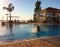 Splash in a swimming pool with bright sun and palm tree