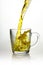 Splash of yellow tea in cup, pouring jet of tea with spray splashes, liquid drink beautiful juicy color with air bubbles and a