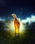 Splashes and bubbles. Glass with light chill beer on grass at football stadium over evening sky with flashlights