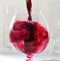 Splashes of red whine while filling a glass