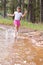 Splashing around is so much fun. A cute little girl running through a wilderness stream.