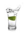 Splashing Mexican Tequila in shot glass with lime isolated on white