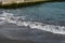 Splashing tide with white foam near old stone pier