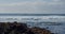 Splashing waves. Close up. Black rocky volcanic beach with black lava stones. Puerto de la Santiago, Tenerife. Punta