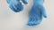 Splatters of spray antiseptic on blue medical gloves.On a white background.