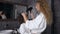 Splendid blond young woman with curly hair in white dressing gown drying her son`s hair in the bathroom