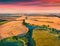 Splendid summer view from flying drone of river in the shape of tree among the field of wheat.