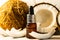 Split coconuts with coconut essential oil. Coconut serum for the face. A bottle of whey oil with a pipette on a white-beige