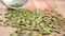 Split green dry peas are thrown from a white bowl on a board in slow motion.