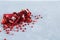 Split ripe pomegranate and grains on a gray white background on wooden table close-up copyspace in the corner of the background