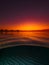 Split view with colorful sunset and underwater sandy sea bottom