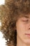 Splited in half cropped portrait of a young curly European man with long curly hair and closed eyes close up. very lush male hair