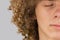 Splited in half cropped portrait of a young curly European man with long curly hair and closed eyes close up. very lush male hair