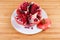 Splitted pomegranate fruit on the white dish on wooden surface