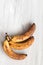 Spoiled tainted bananas on grey background. Ugly food trendy photo. Food waste, food garbage