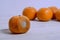 Spoiled tangerine with mold in front of ripe good tangerines on a white background. The concept of an outcast from society, unlike