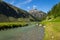 Spol River flowing in Lake Livigno, Corno Brusadella Mountain background