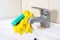 Sponge and gloves for washing dirty faucet with limescale, calcified water tap with lime scale on washbowl in bathroom, house