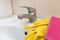 Sponge and gloves for washing dirty faucet with limescale, calcified water tap with lime scale on washbowl in bathroom, house