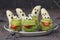 Spooky banana ghosts monsters and green kiwi monsters for Halloween party on brown background decorated with spiders and