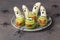 Spooky banana ghosts monsters and green kiwi monsters for Halloween party on brown background decorated with spiders