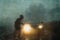 A spooky blurred hooded figure. Moving in front of car headlights. On a spooky country track. On a misty evening in the