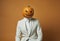 Spooky businessman wearing a carved pumpkin mask.