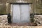 Spooky and Creepy Gray Steel Double Door Leading into Damp Concrete Building