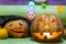 Spooky custom weird handmade orange pumpkin head with carved faces and glowing candle or light inside. Halloween party