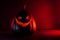 Spooky halloween black pumpkin, Jack O Lantern, with illuminated evil face and eyes on bloody red and black background