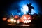 Spooky Halloween pumpkin with blue mist and scarecrows