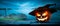 The spooky haunted evil glowing eyes of Jack O\' Lanterns, halloween pumpkin, on the right of a wooden bench