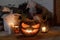 Spooky Jack o lantern, spiders, pumpkin and glowing candles in dark. Halloween porch and entrance decor. Scary halloween