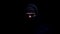 Spooky man in balaclava and hood looking into camera, member of gangster group