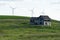 Spooky, old abandoned farm house in the rolling hills of The Palouse in Washington State. Windmills in background