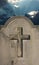 Spooky old cemetery headstone against stormy atmospheric sky