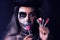 Spooky portrait of woman in halloween gotic makeup holding lillipops