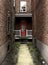 Spooky red door surrounded by brick walls